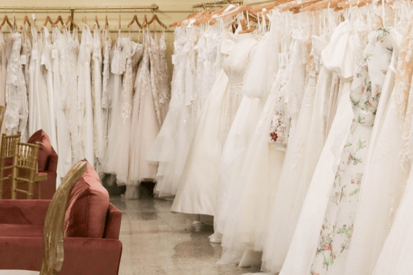 A bridal gown showroom featuring outdoor wedding dresses, including styles perfect for a garden wedding dress or a beach wedding dress, elegantly displayed on hangers with plush seating for a comfortable browsing experience.